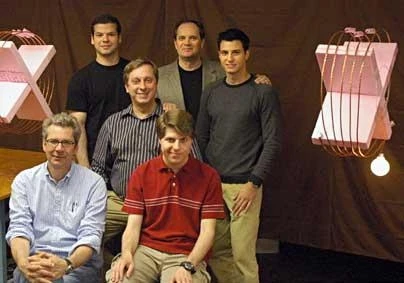 Wireless power transfer over two-meter distance, from the coil on the left to the coil on the right, where it powers a 60W light bulb. Members of the team that performed the experiment are obstructing the direct line of sight between the coils; front row: