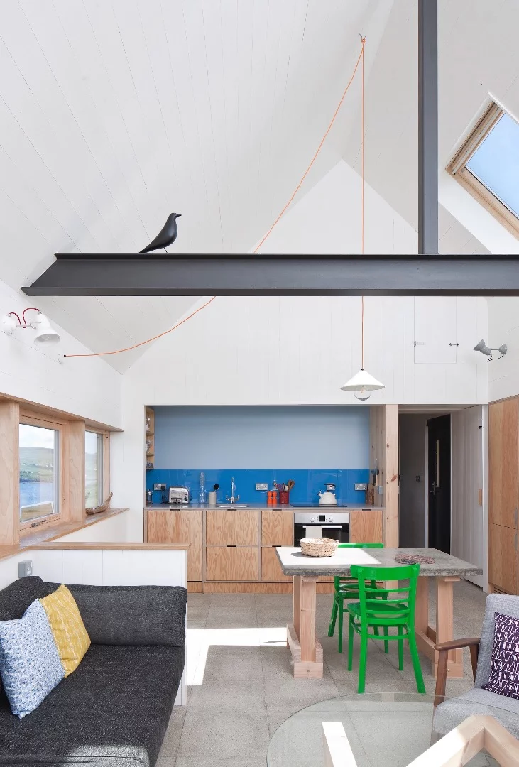 The interior is arranged as a simple cabin wth one bedroom, lounge area, kitchen, and bathroom