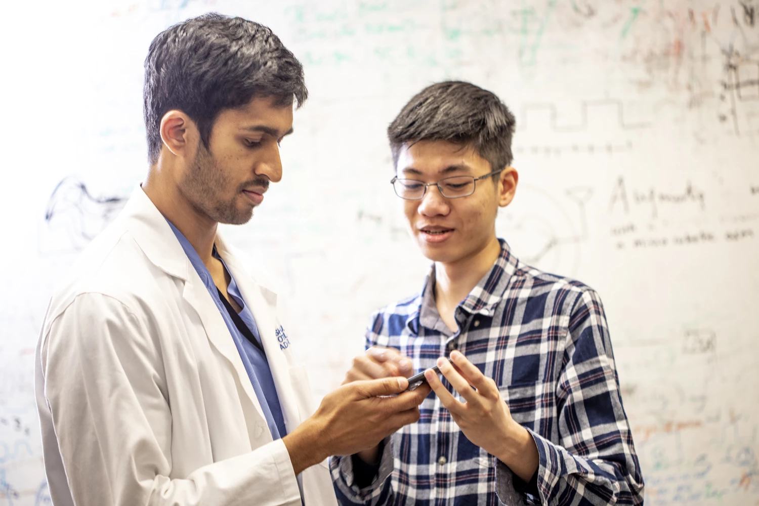 Dr. Sharat Raju (left) and Justin Chan discuss the app