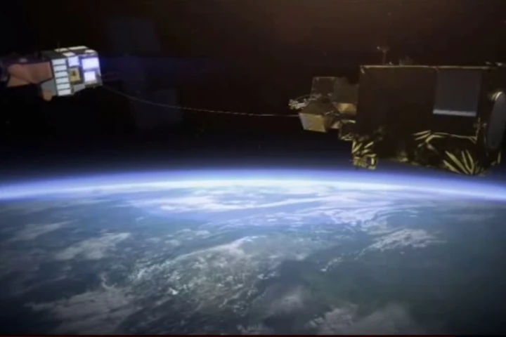 Artist's concept of a derelict satellite being reeled in after being harpooned by the e.DeOrbit satellite (Image: Airbus Defence and Space)