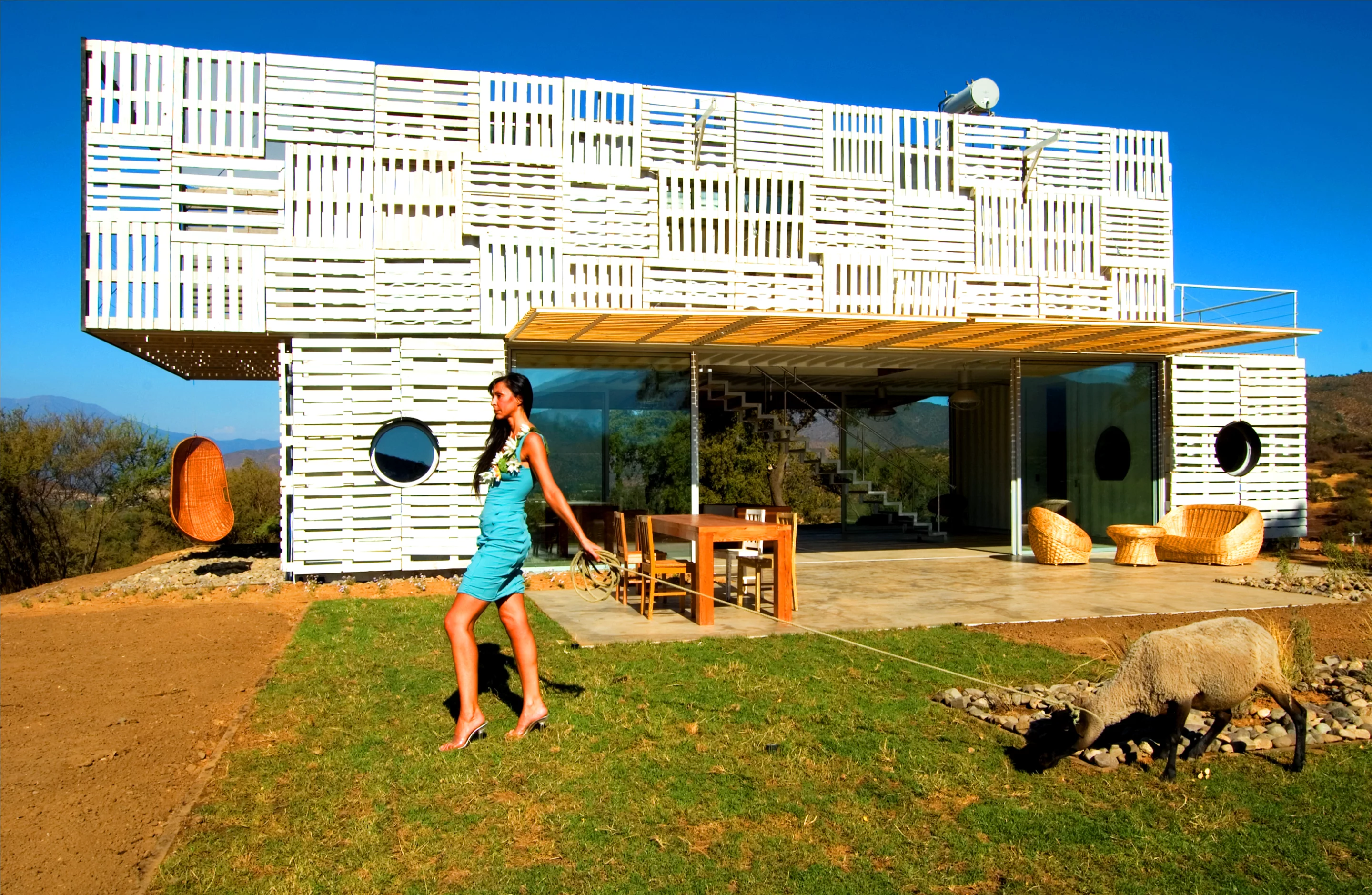 Manifesto House's thermal performance is improved with the use of adjustable wooden solar shading made of wood from sustainable forest sources on one side, and making novel use of forklift pallets on the other