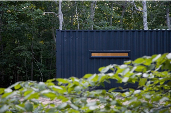 The Container Studio was painted charcoal to blend in with its surrounding landscape