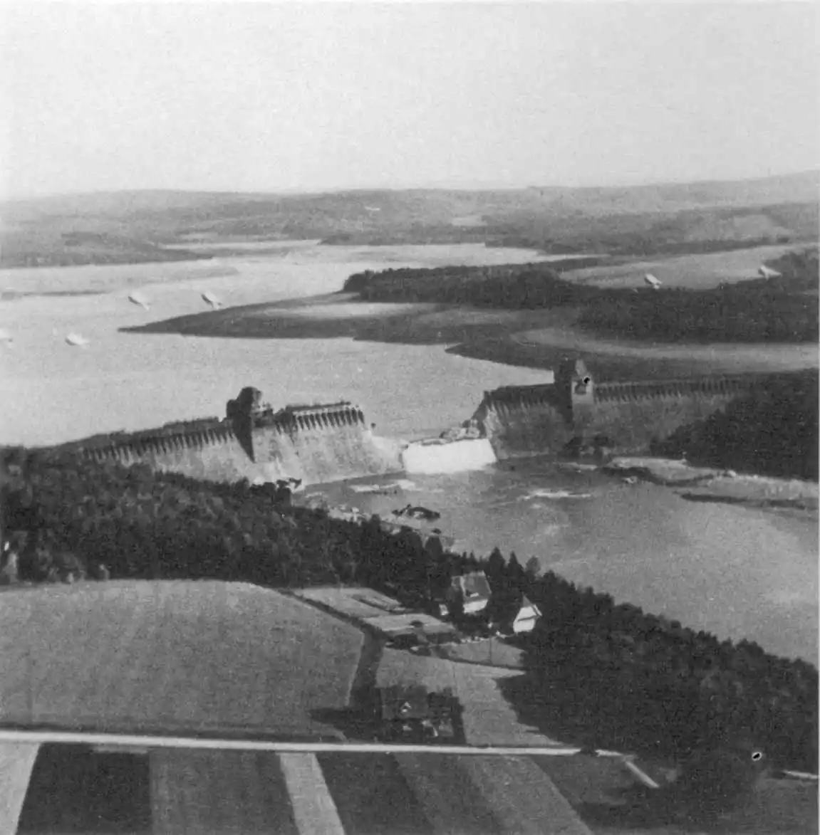 Wallis arrived at the idea of a bouncing bomb when thinking about how he, as an engineer, might help shorten World War II. His idea was that a bomb dropped from an aircraft could be made to bounce along the surface of a river before striking a dam where it would sink and detonate. The bouncing would allow evasion of anti-torpedo nets placed in the river to protect the dams, and allow the bomb to explode right next to the dam, where it would be most effective, and potentially breach. Numerous tests were carried out before arriving at the dustbin-shaped Upkeep bomb design, and determining optimal backspin and drop height. On May 16, 1943, 19 modified Lancaster Bombers left on their mission to destroy the Möhne, Eder and Sorpe Dams in an effort to disrupt Nazi supply lines. After several attempts, the Möhne and Eder Dams were breached, though the Sorpe Dam obtained less damage. Eight aircraft were lost, with 53 of the 56 crew aboard them killed. The mission is thought to have resulted in more than 1,300 causalities on the ground, many of whom were overseas workers. The mission did strike the Nazi war machine, however, destroying 25 bridges, 11 factories, and various other mines and infrastructure, and damaging many more.