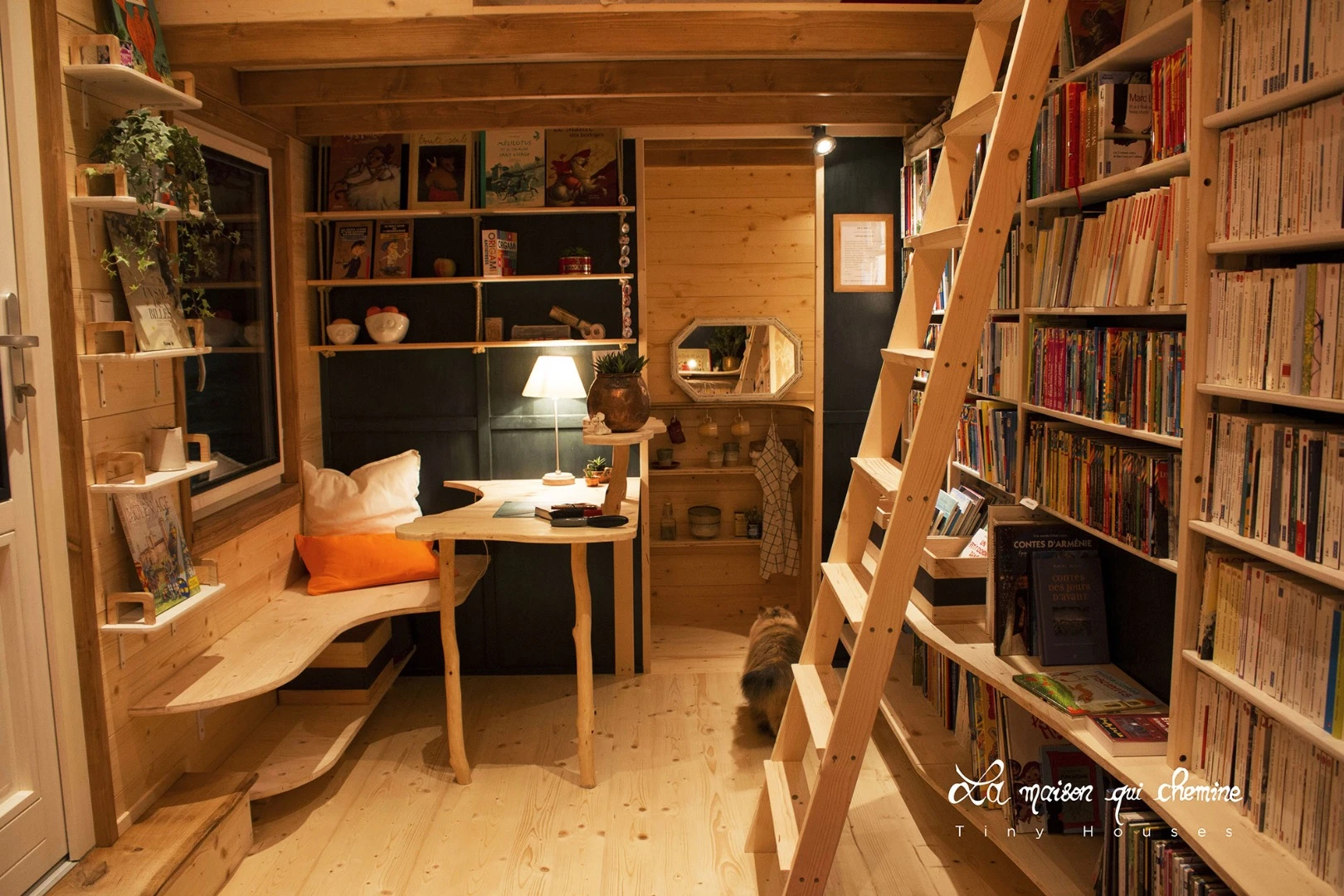 A wooden ladder provides access to hard to reach books and the small sleeping loft