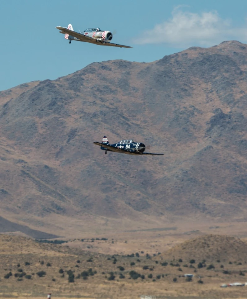 Two T-6 planes with the spectacular, mountainous Reno landscape behind them