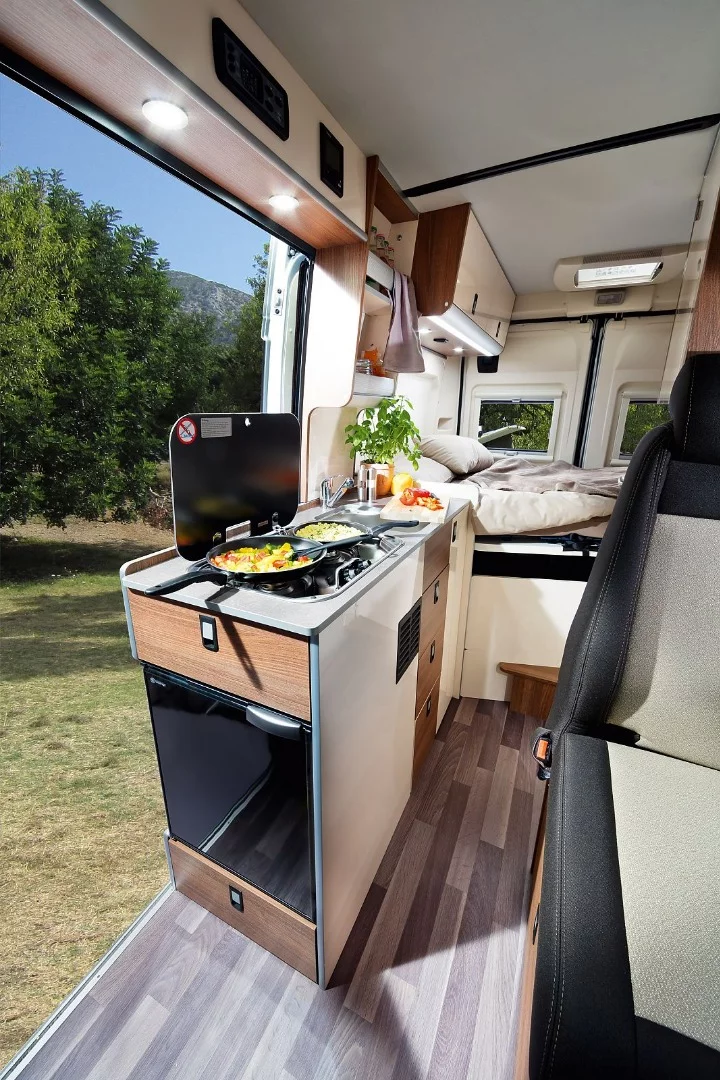 The kitchen block includes a sink, double-burner stove and refrigerator