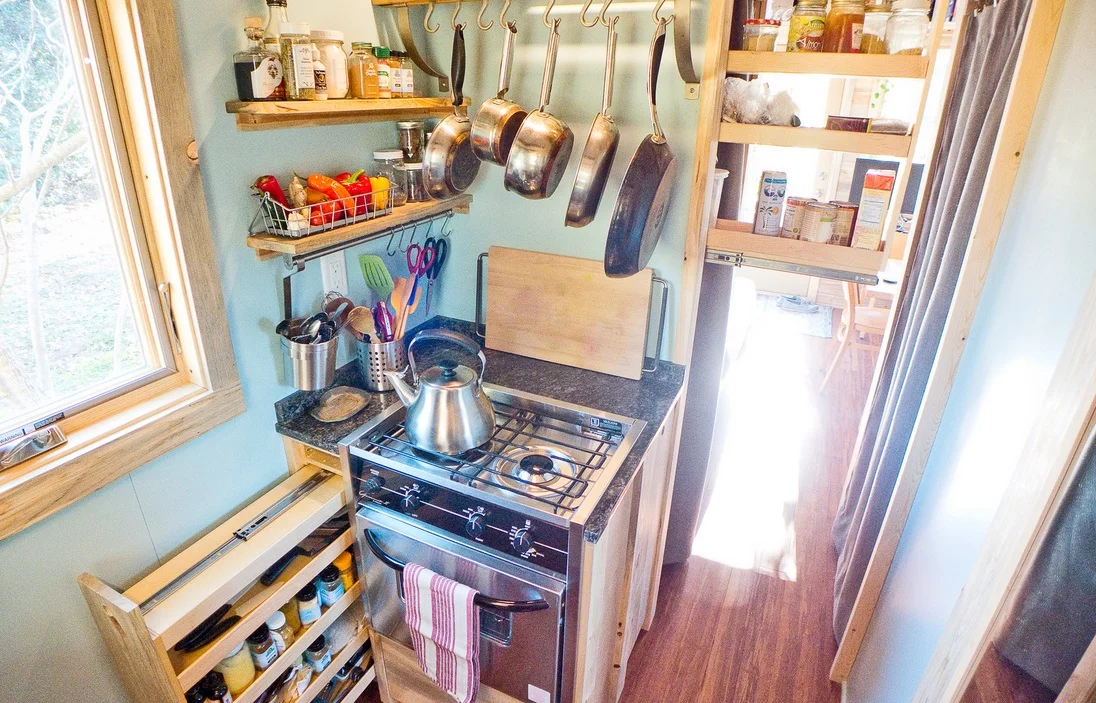 The kitchen features a two-burner stainless steel range stove with oven unit and a stainless steel counter-height fridge
