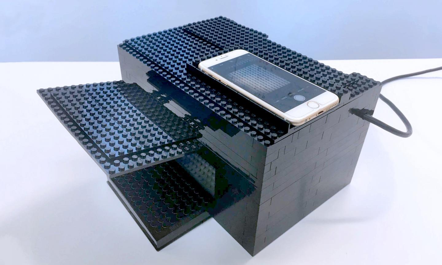 The Lego box is equipped with a UV/vis lamp, a hole for the iPhone camera, and guides for camera and plate placement