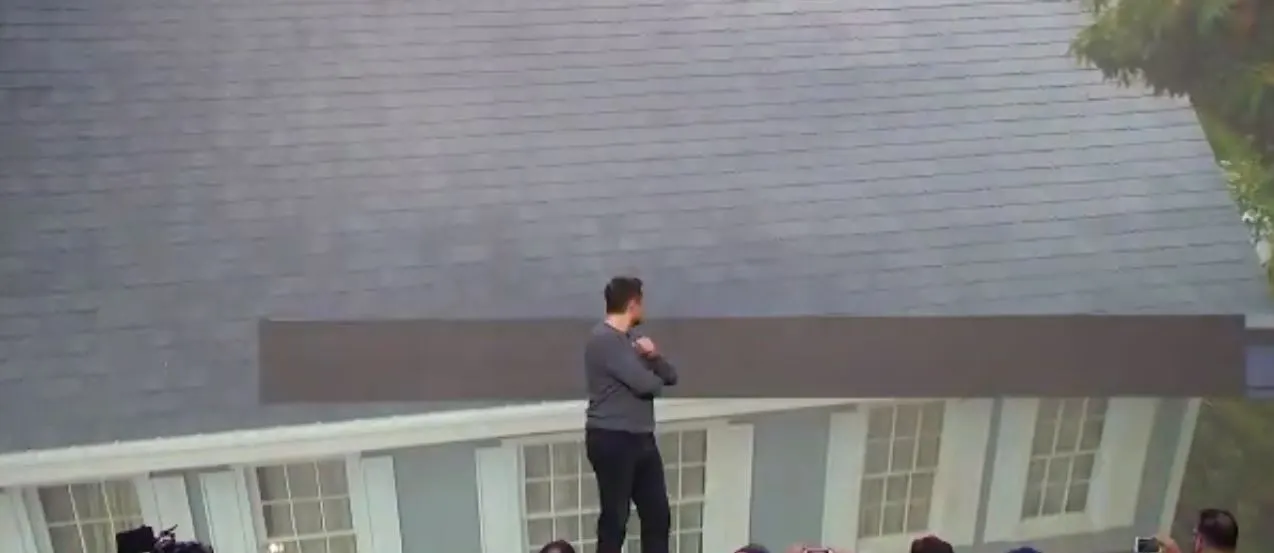 Tesla CEO Elon Musk admires his company's new solar roof tiles