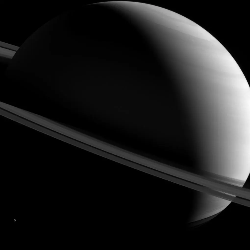 The Sun's illumination lingers over Saturn's north pole as ghostly, partially-lit rings streak accross her surface