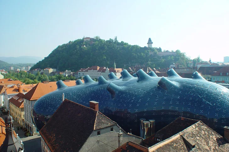 The Kunsthaus Graz is an art museum in Austria that resembles a strange alien blob sitting among traditional European buildings