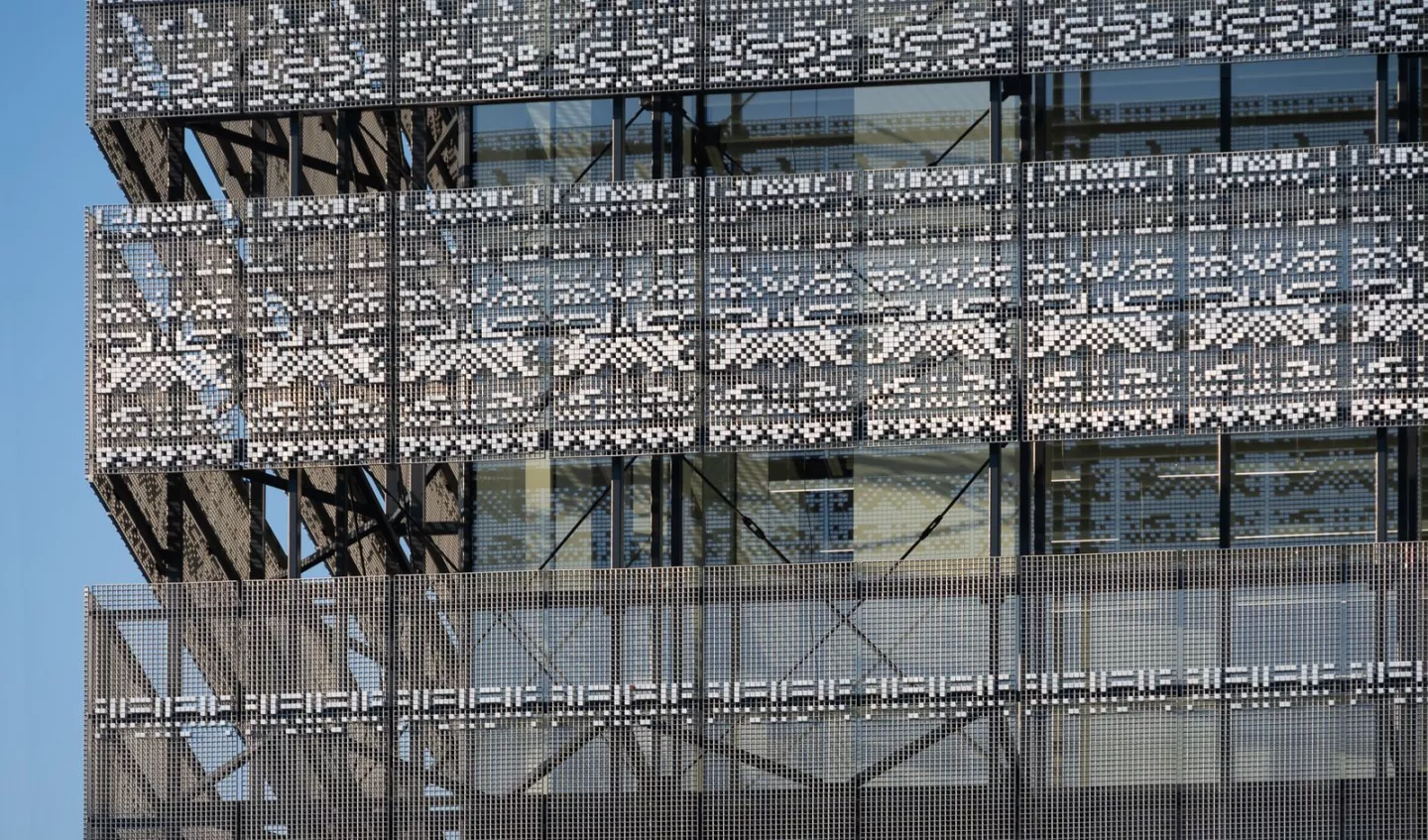 The Museum of Ethnography's glazed exterior is shaded by an aluminum screen