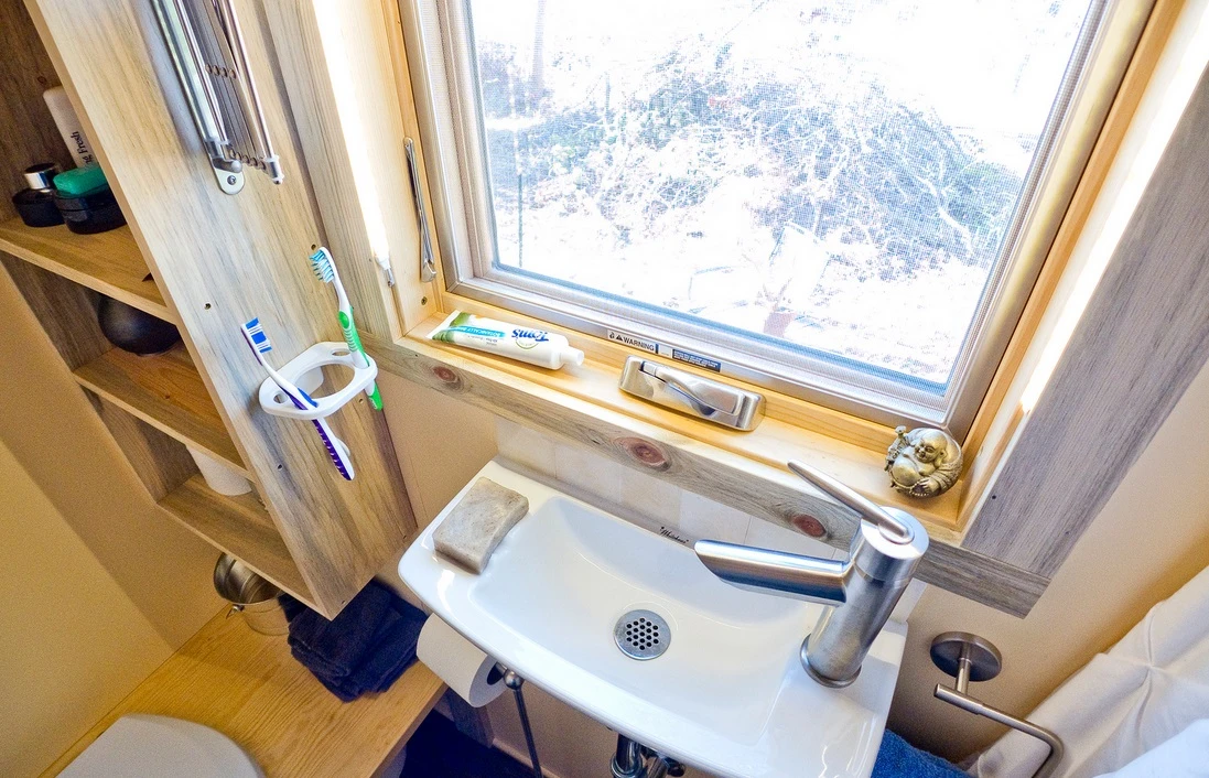 The bathroom has a small hand basin that fits nicely underneath the window