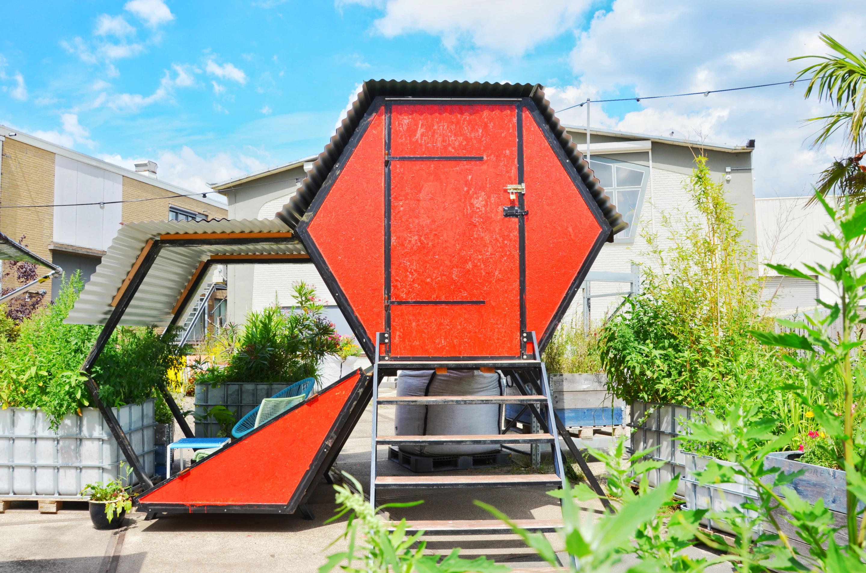 Honeycomb is made from scrap materials and consists of a hexagonal structure with a bedroom and a small patio area
