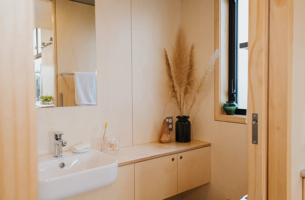 The First Light Tiny House bathroom includes vanity unit, shower, and composting toilet