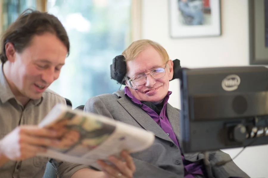 Professor Stephen Hawking and his Care Taker Pete read the newspaper
