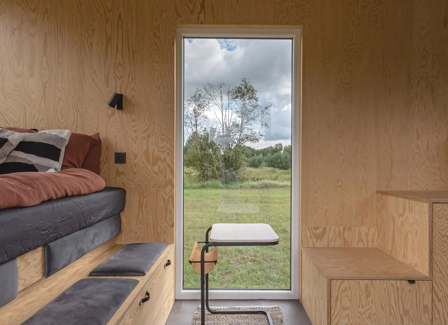 The BTH Loft off-grid's living area includes some seating with integrated storage, plus a small dining table