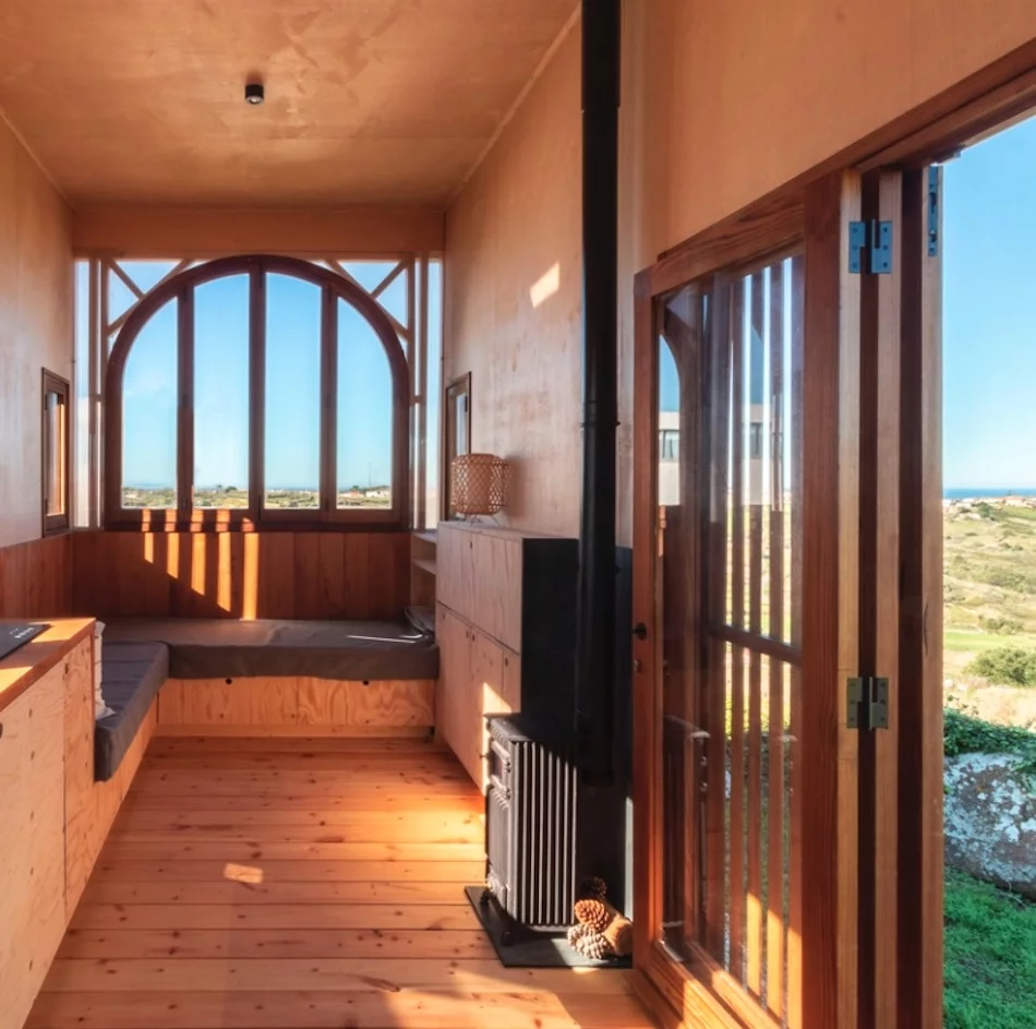 The Vigia's living room includes a large L-shaped sofa and a wood-burning stove