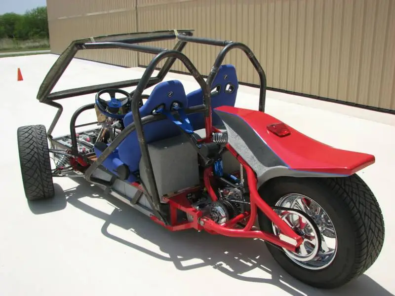 The ZW2C has a Honda Fit windshield, a shifter for park/reverse/drive/economy mode, a parking brake, and a composite rear fender