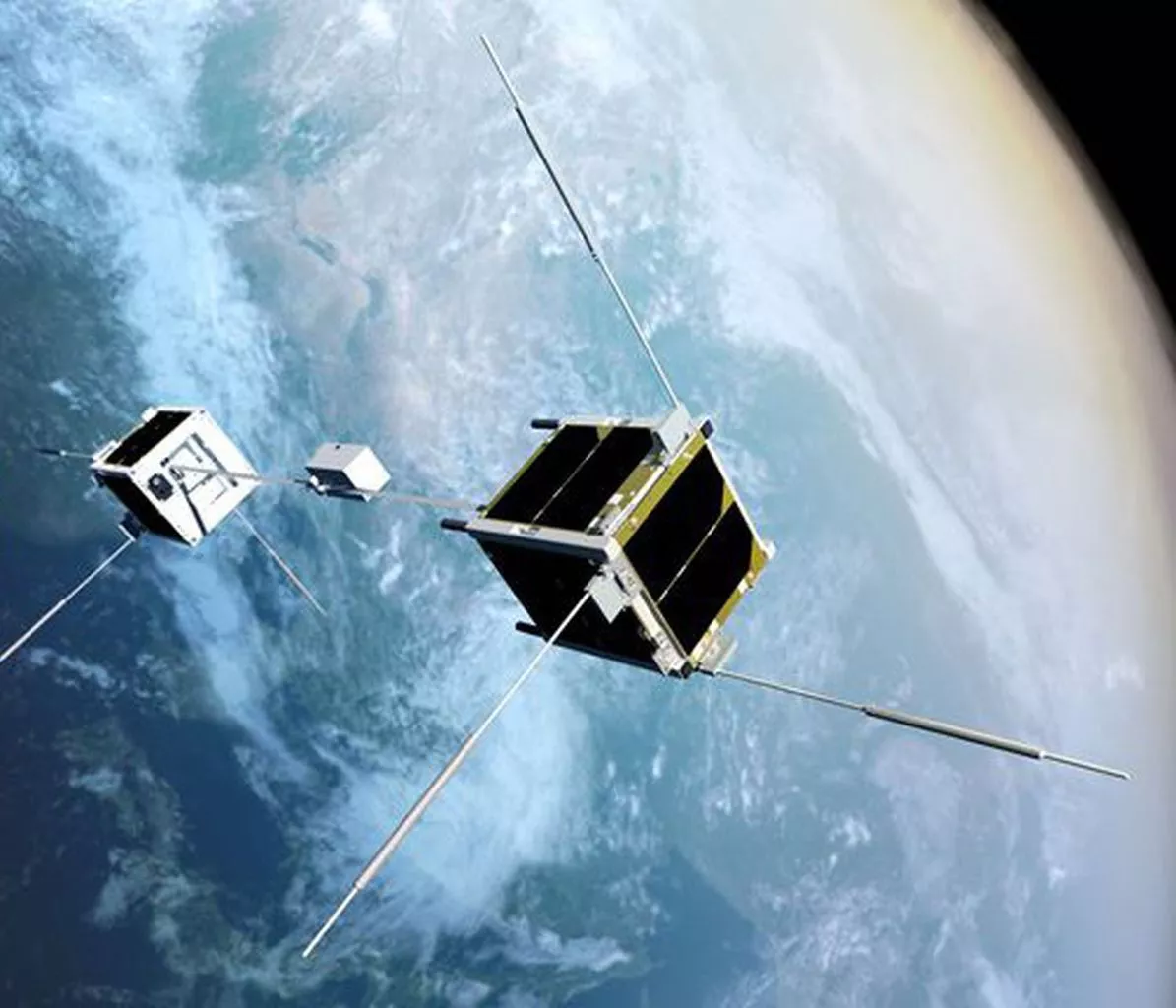 An artist's conception of the STARS-Me satellites, two CubeSats connected by a tether with a robot that climbs between them
