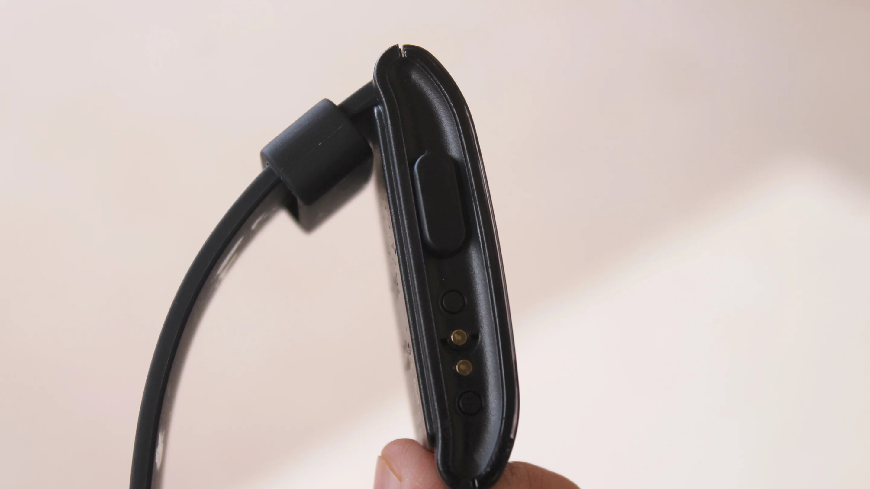 The Pebble's left side features a back button and a charging port