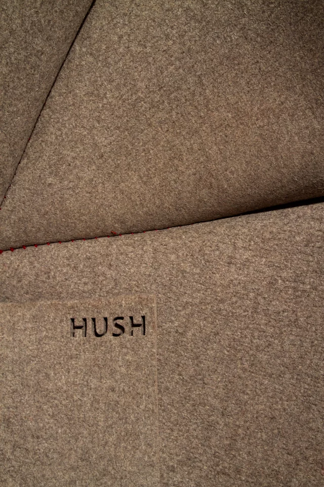 Made from a single piece of water jet-cut 12-mm thick (0.5-in) industrial felt 1750 x 4000 mm (69 x 157 in) in size, HUSH is sewn by hand with 150 meters (490 feet) of wool yarn
