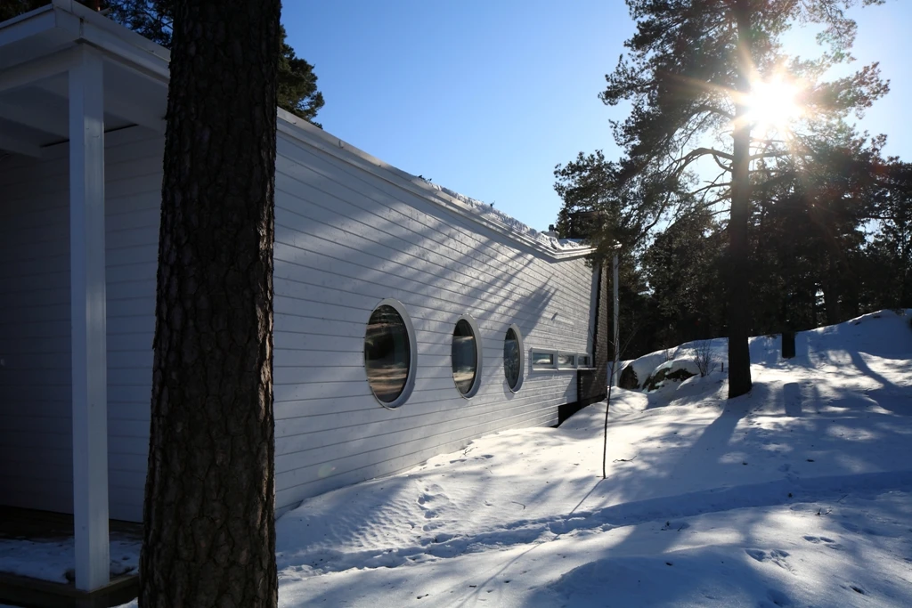 The building is nestled amidst its natural surroundings of rock beds and trees