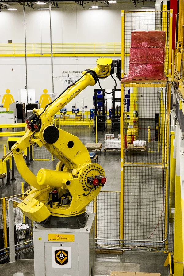 Amazon's Robo-Stow, one of Earth's largest robotic arms, moving products directly to a Kiva robot in its newest-generation fulfillment center