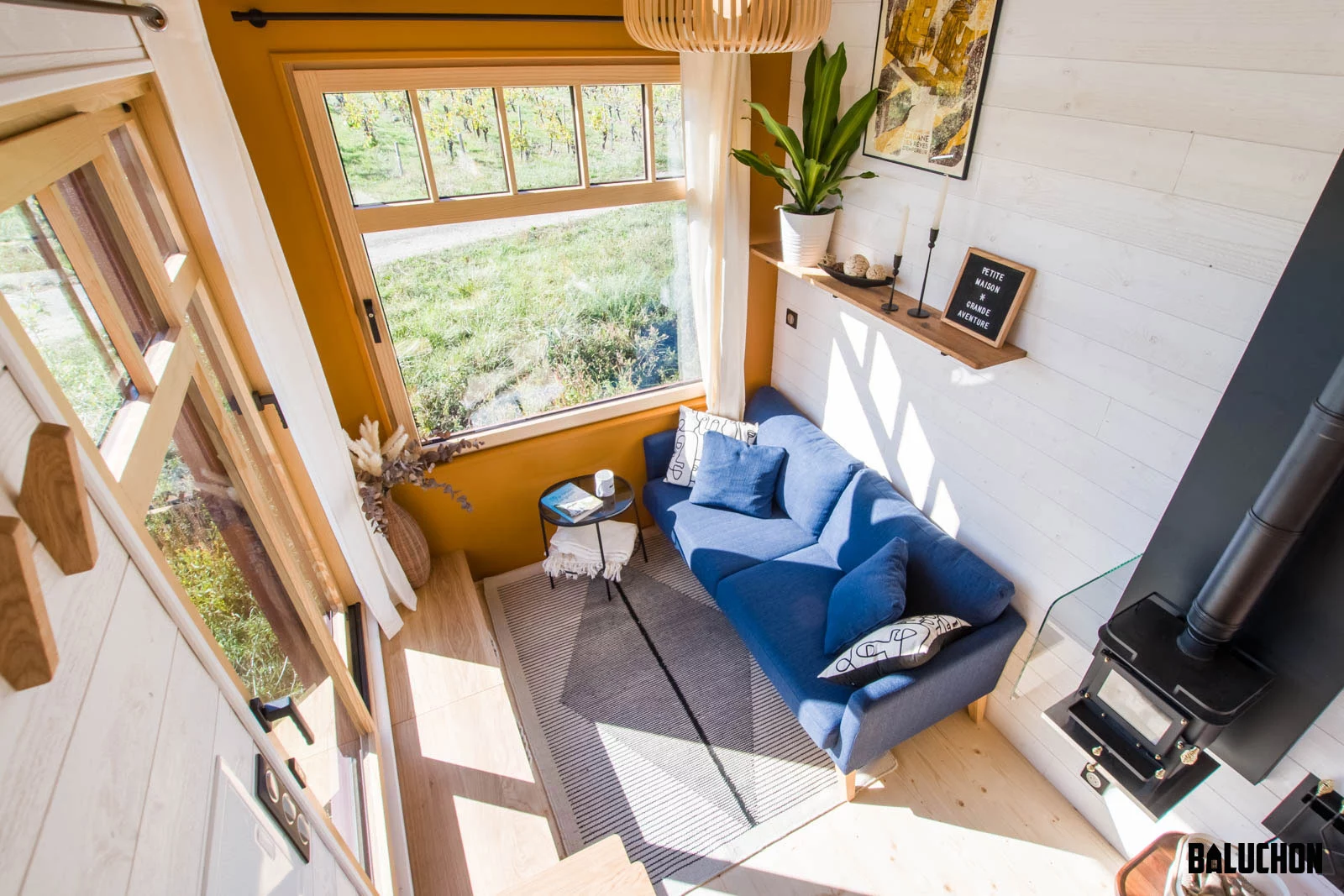 Visitors enter into the Golden Hour's living room, which includes a sofa, some storage space, and a small table
