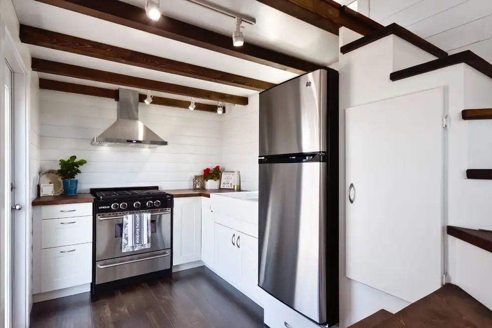 The kitchen includes a stainless steel fridge/freezer and propane-powered oven