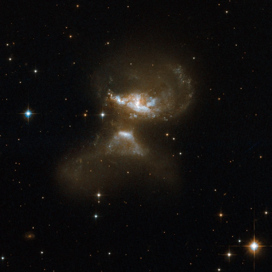 MCG+12-02-001 consists of a pair of galaxies visibly affected by gravitational interaction as material is flung out in opposite directions