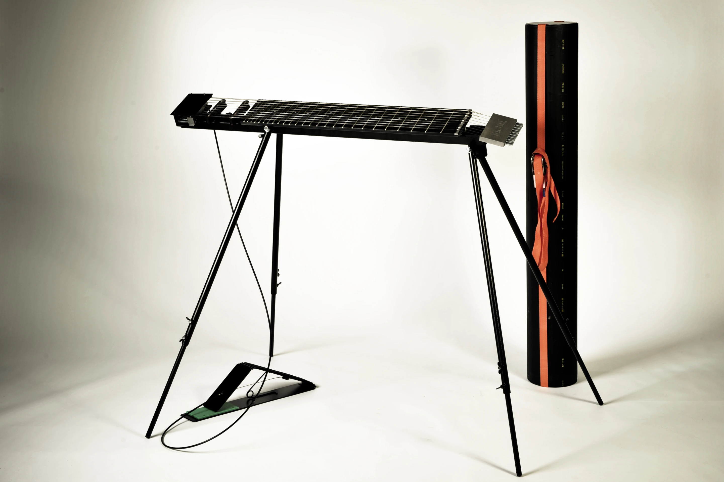 The Kelstone 9-string instrument with its dynamic muter pedal and tube carry case