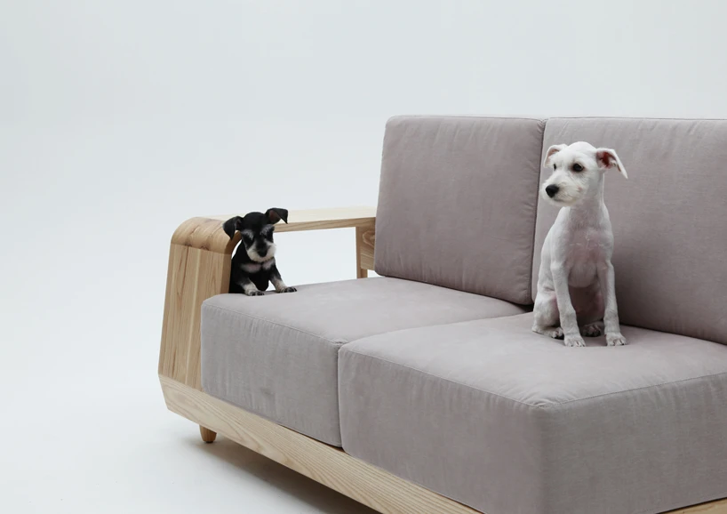 The simple sofa seats two people, and features durable fabric upholstery and a solid ash wood frame
