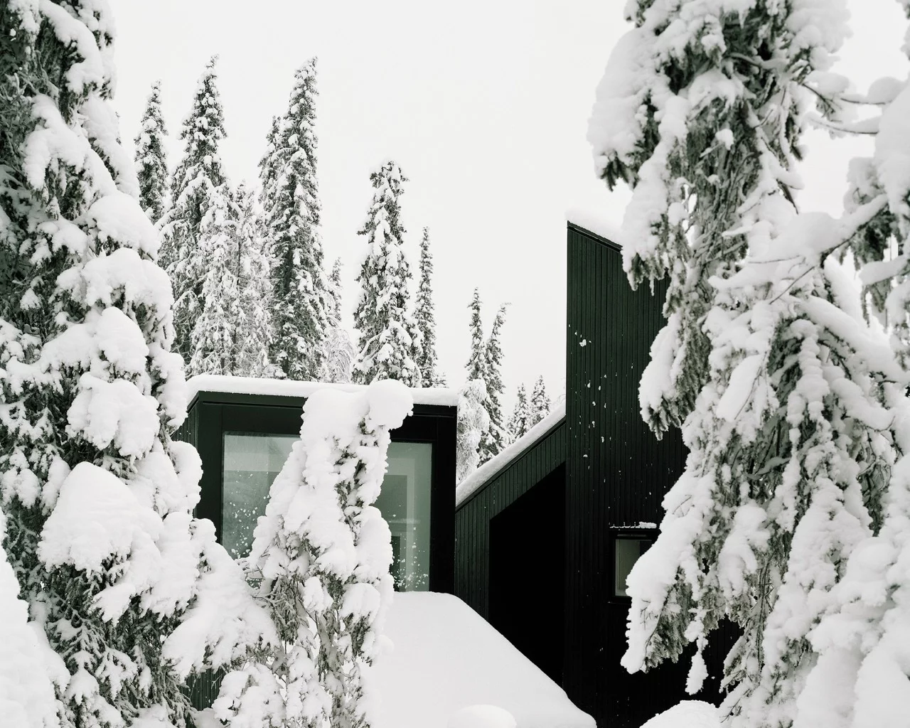 Located deep in the woods near Lillehammer, Norway, Cabin Vindheim consists of a series of sharply sloping roof sections that lend the impression of a larger structure hidden beneath the snow
