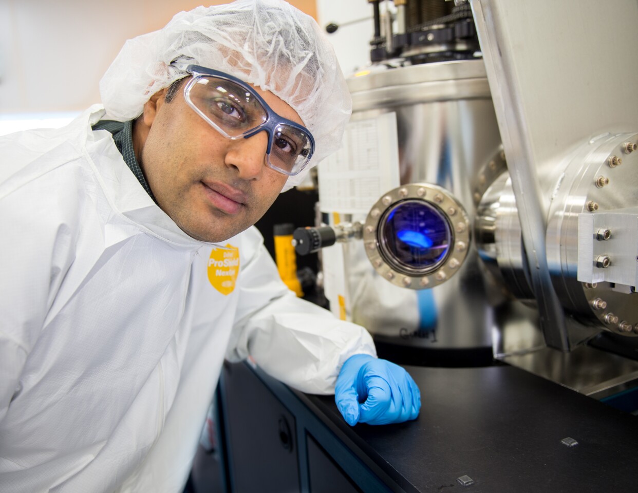 Vivek Dwivedi, in front of a sputtering reactor used to deposit vanadium-oxide onto sample substrates
