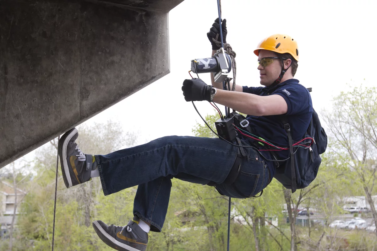 Engineering student Brady Morton uses the winch device to ascend a tower