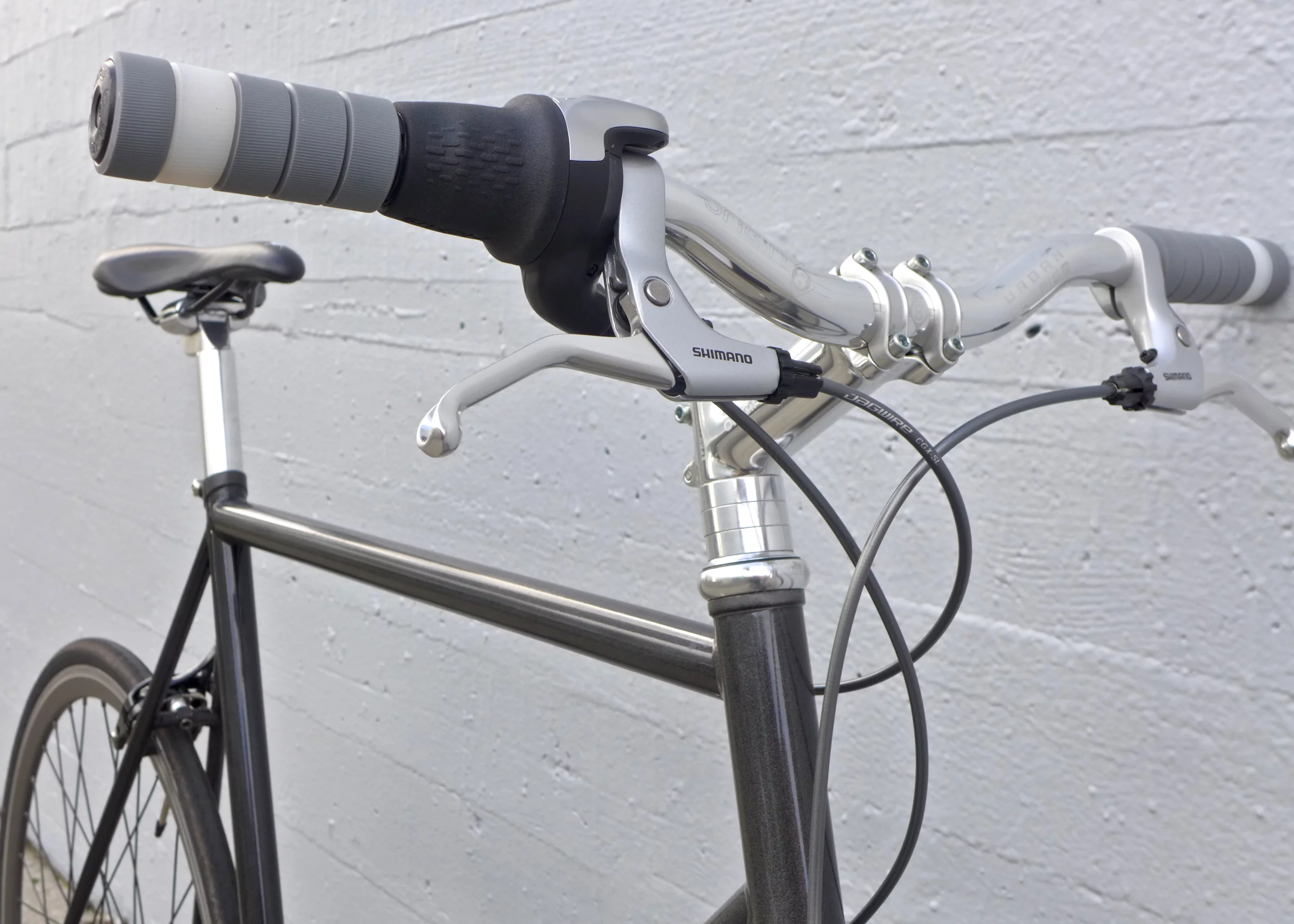 The Lumen 8 features upright riser handlebars, cables fed through a Sutro frame, brakes front and rear