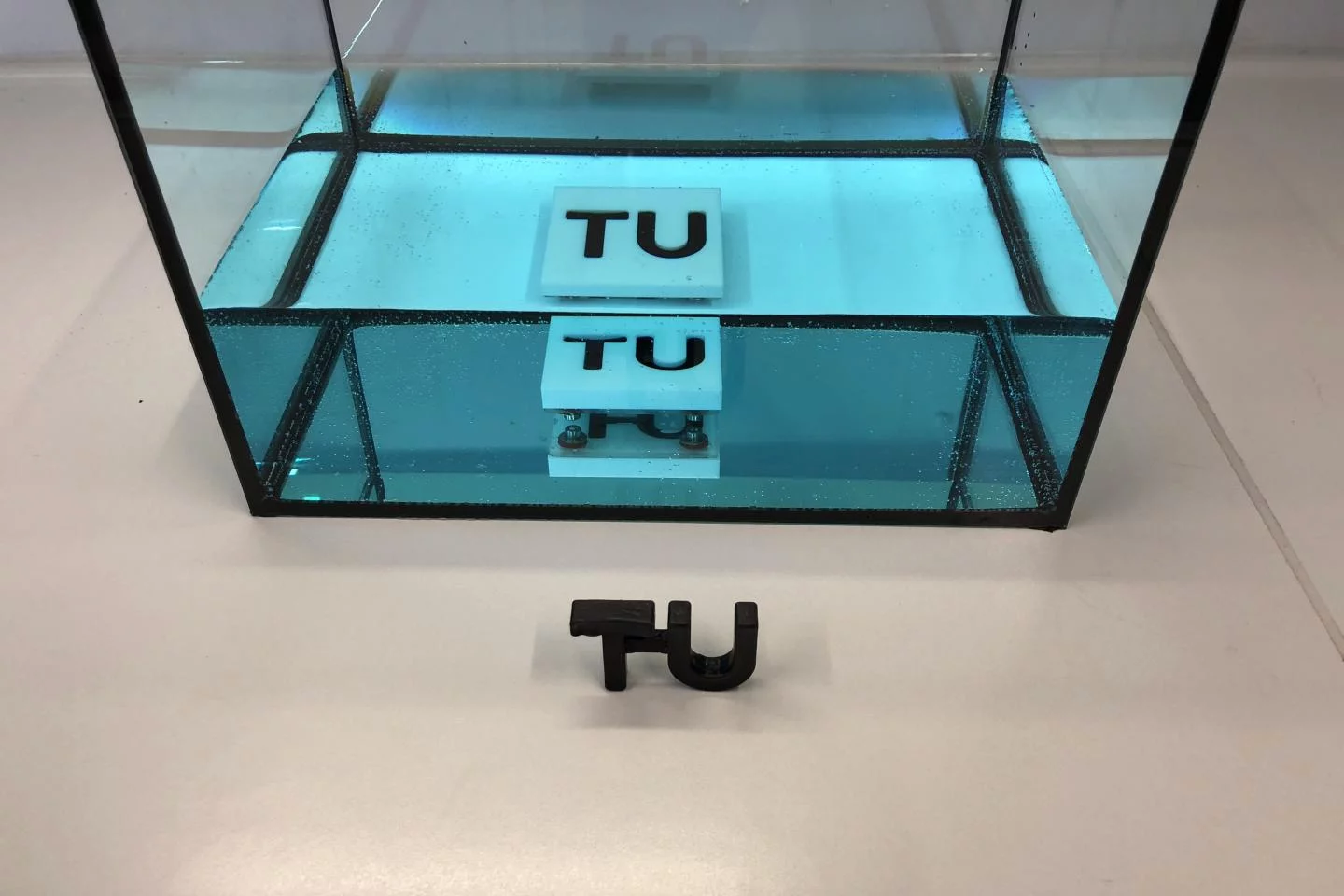 A sample of resin (black TU logo), that cured while submerged in a tank of water