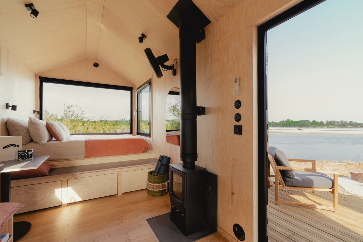 The bedroom/living area includes a raised double bed with integrated storage