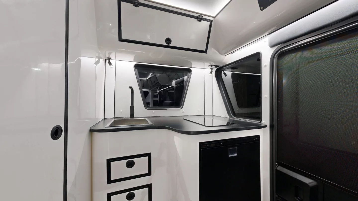 The kitchen has an induction cooktop, sink and fridge