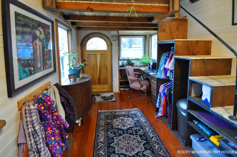 Access to the master bedroom in the Red Mountain 34' Tiny House is gained via storage-integrated stairs