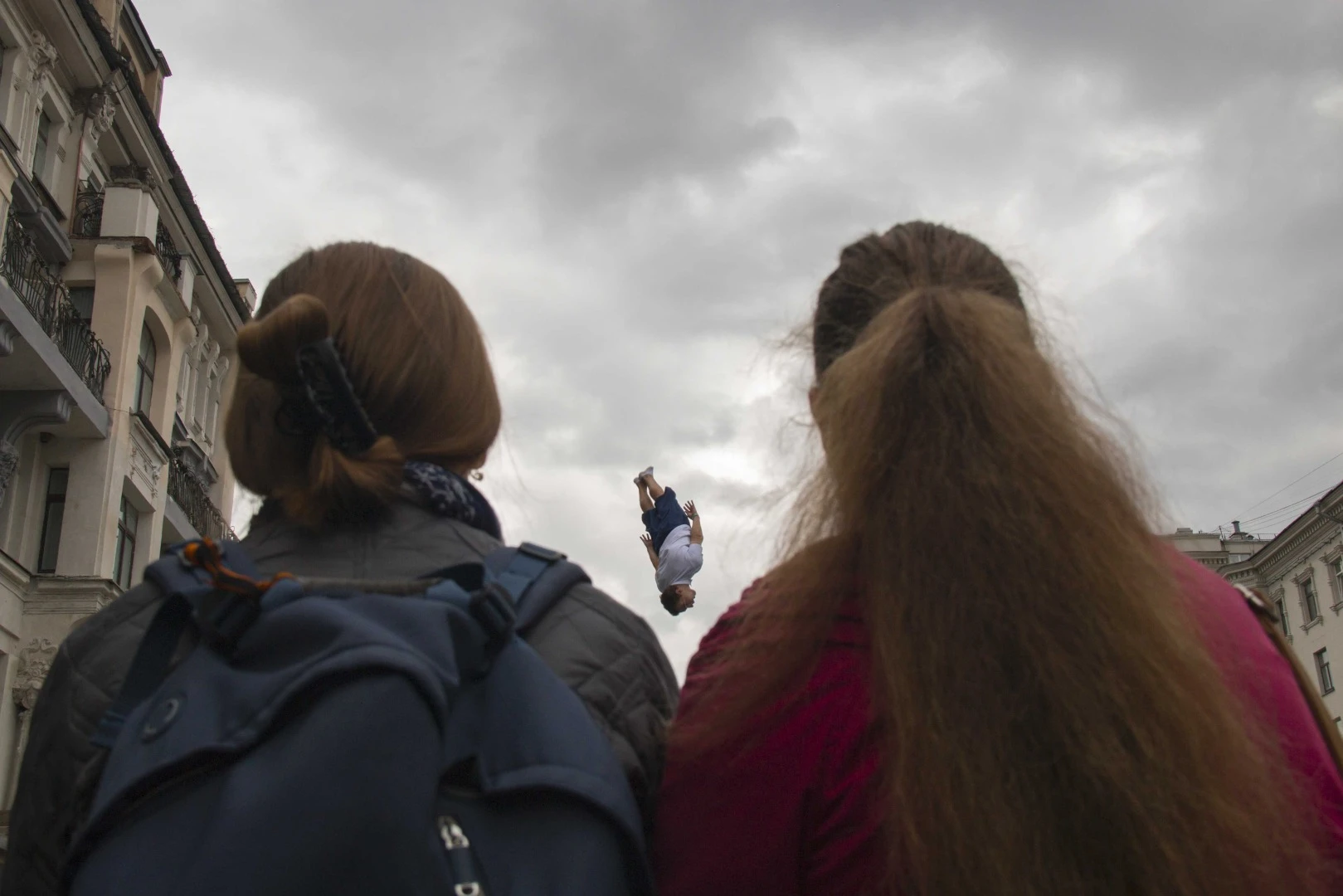 Finalist in The Photojournalist category of the 2018 EyeEm Awards. From the photographer: "This photo was taken in the city of Moscow on the holiday dedicated to the city. It was a great day to look for a photo frame. The guy fell from the sky and he had a choice between the girls, to whom to fall into the arms of love, but he was not determined and flew between them."