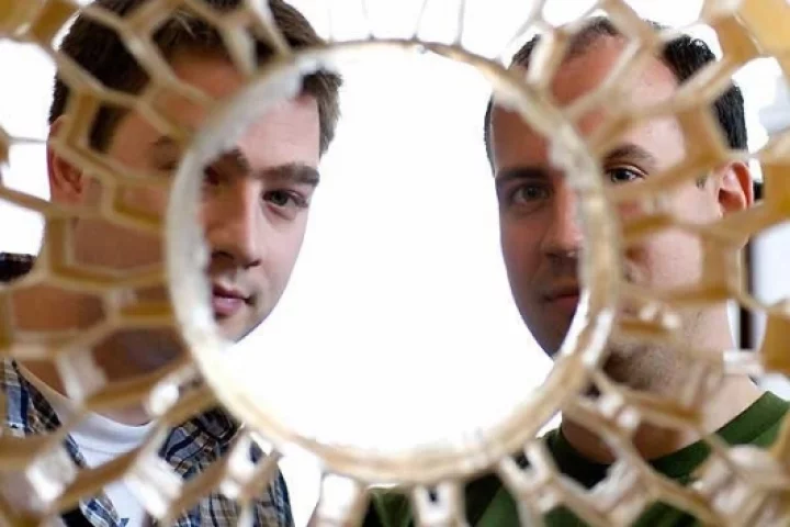Eric Foltz (left) and Nick Newman look through the honeycomb pattern of an early prototype of a non-pneumatic tire. Foltz, Newman and Osswald (not pictured), worked with Resilient Technologies to design and develop the airless vehicle tire for military us