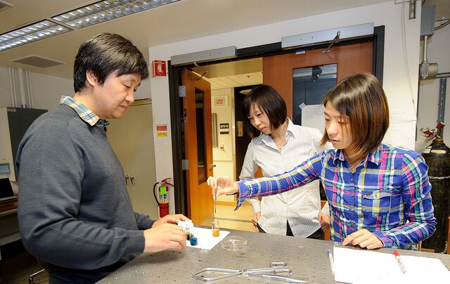 Assistant Professor Xiaolin Zheng (center) watches as post-doctoral fellow In Sun Cho (left) and PhD student Yunzhe Feng (right) dip nanowires in the gel solution