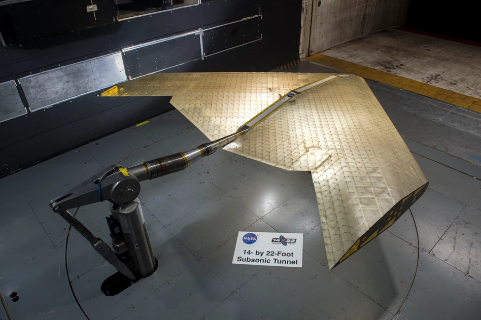 Wing assembly is seen under construction, assembled from hundreds of identical subunits. The wing was tested in a NASA wind tunnel
