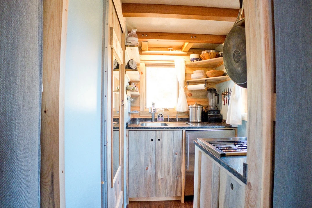 The kitchen features a two-burner stainless steel range stove with oven unit and a stainless steel counter-height fridge