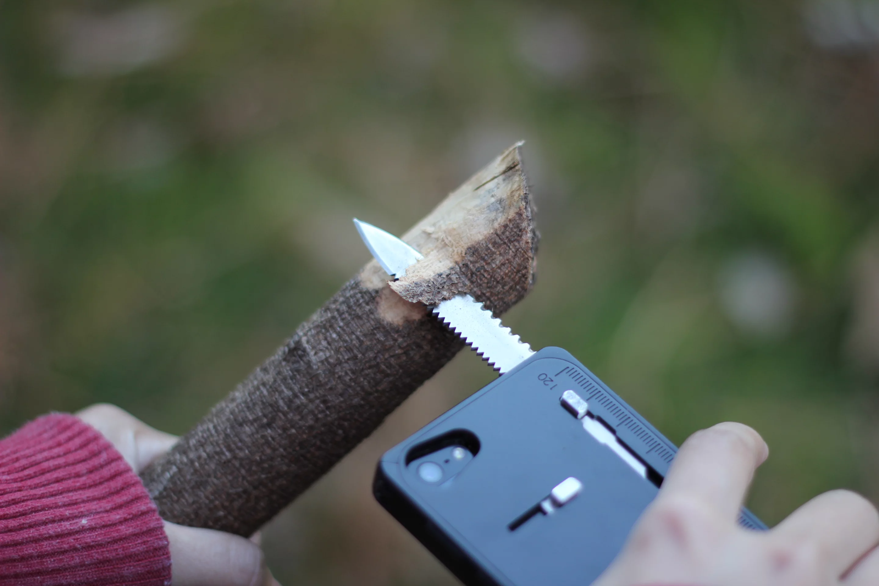 The knife has fine and serrated edges on one side and a wood saw on the other