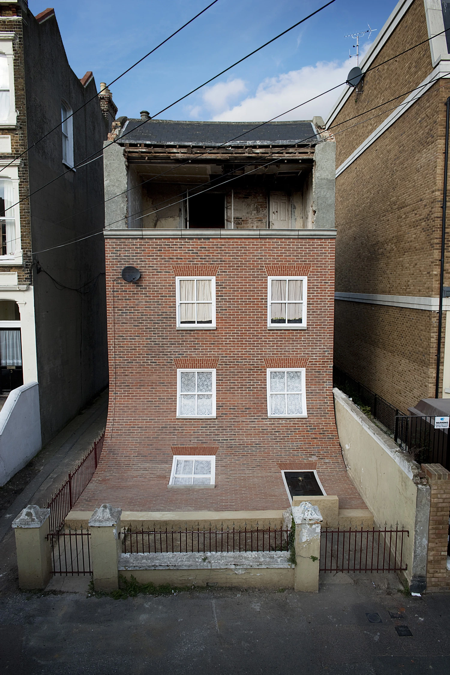 A gaping cavity exposes the innards of the top floor.(Photo: Alex Chinneck)