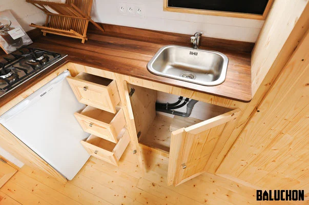The kitchen includes a four-burner stove, fridge, and sink