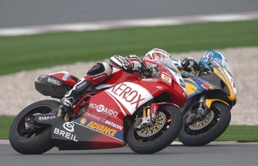 Regis Laconi's Ducati 999 and Yukio Kagayama's GSXR1000 exit a turn side by side at Losail.